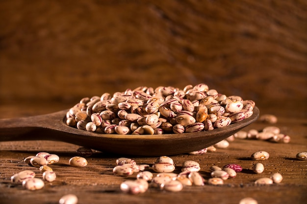 beans into a bowl on wooden table