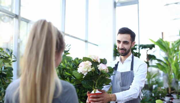 Photo beard gardener holding hydrangea in flowerpot