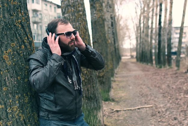 Barba uomo nel parco con cuffia