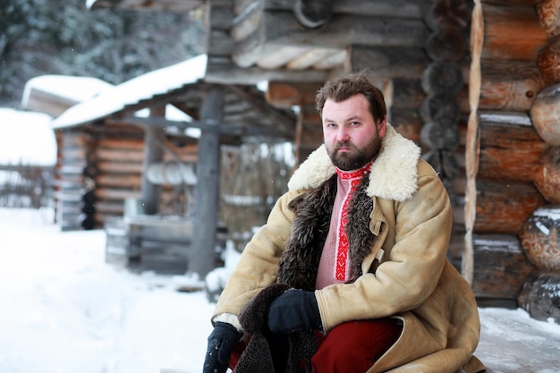 ロシアの農民中世の伝統的な冬の衣装でひげを生やした男