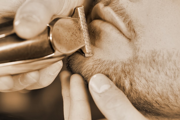 Beard trimming. Cropped closeup of a man beard being trimmed by a barber