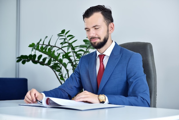 Bearded accountant man sitting in office and analyzing business report