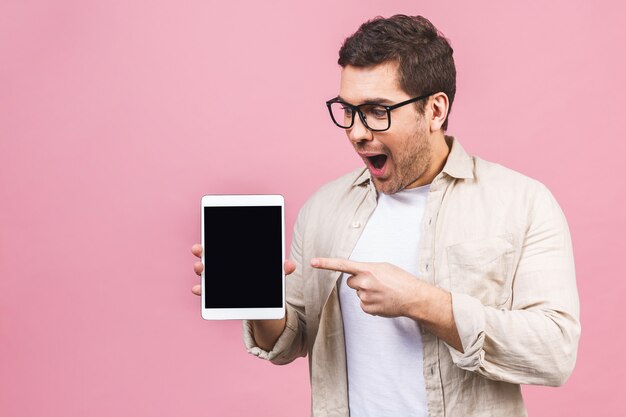 Bearded amazed shocked man in eyeglasses which showing blank tablet computer screen.