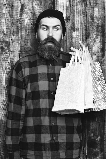 Bearded brutal caucasian hipster with moustache holding shopping packages