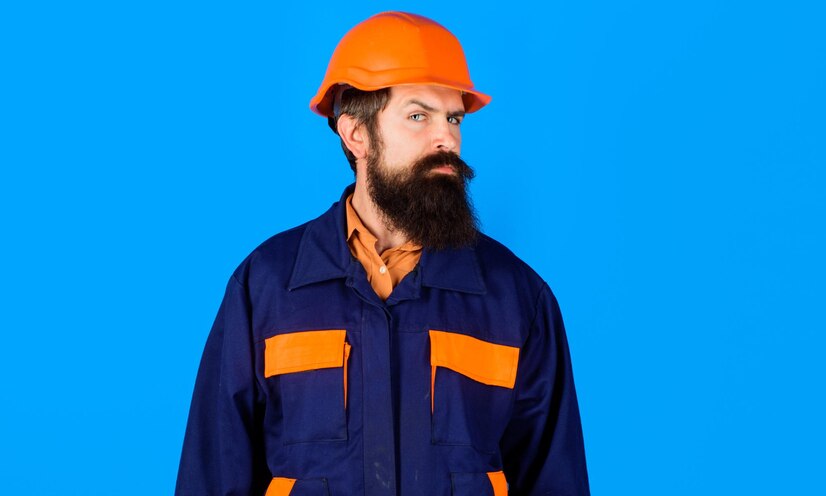  Bearded builder or architect in uniform and safety helmet construction worker in hard hat