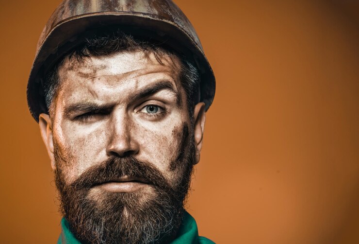  Bearded builder in hard hat portrait of serious handsome engineer mechanical worker in protective