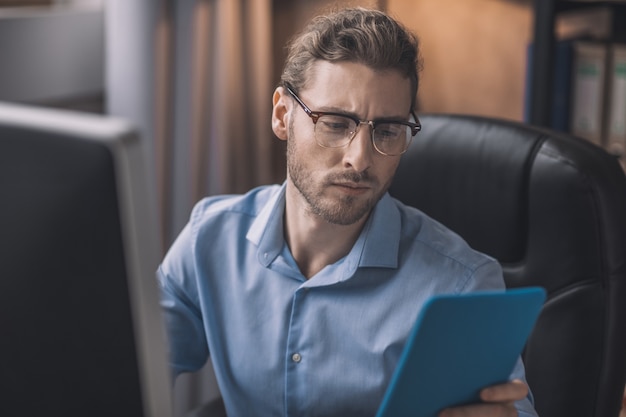 Bearded businessman in blue shirt working under project