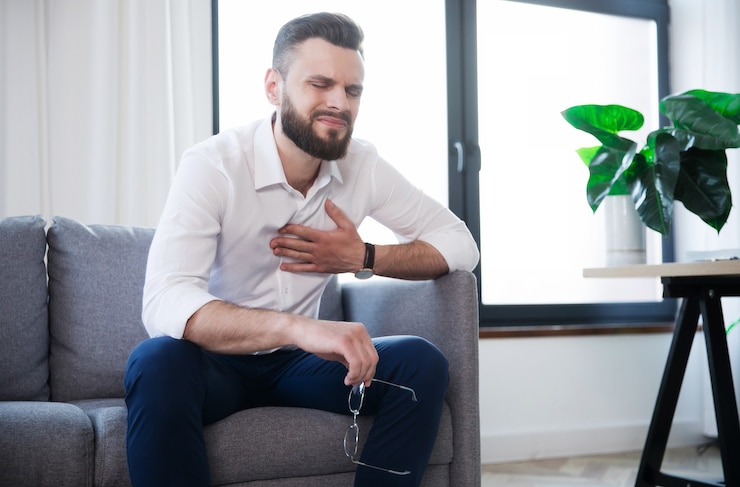Photo bearded businessman has a heart attack due to stress and hard work