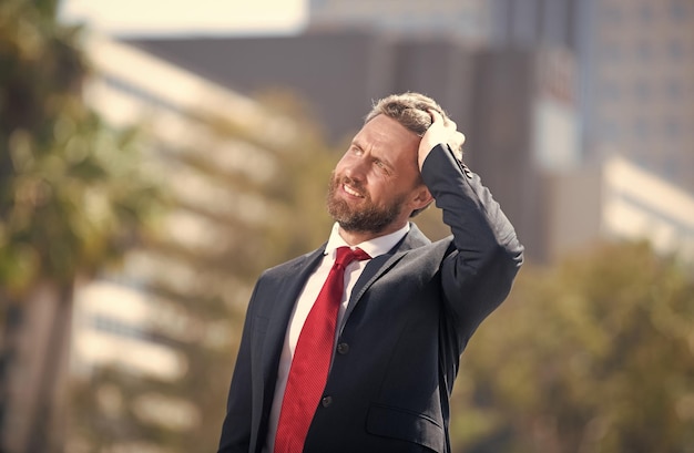 Bearded businessman looking up on urban background business man