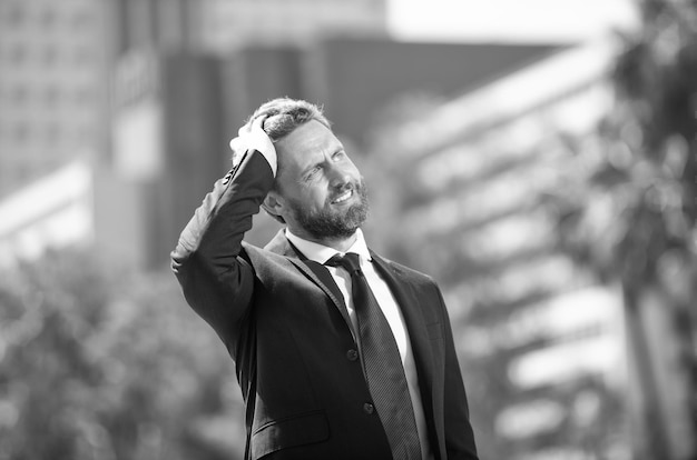 Bearded businessman looking up on urban background business man