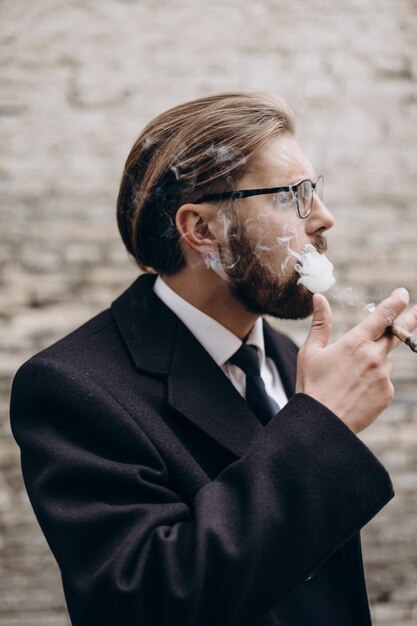 Bearded businessman smoking cigarette outdoors