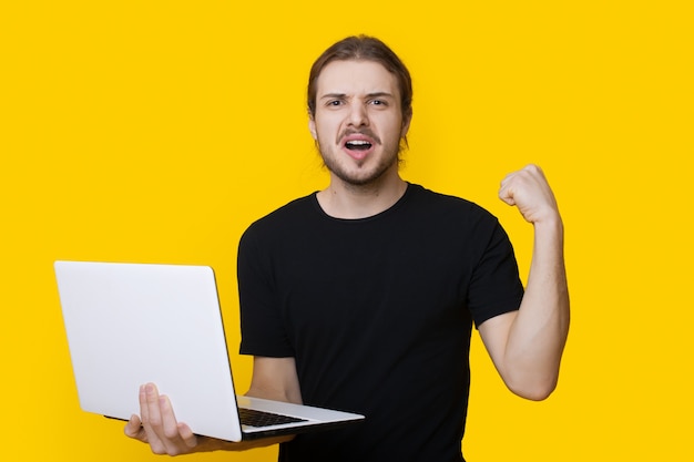 Bearded caucasian man is gesturing the yes signholding a laptop