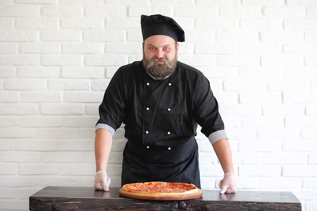 Bearded chef chef prepares meals at the table in the kitchen