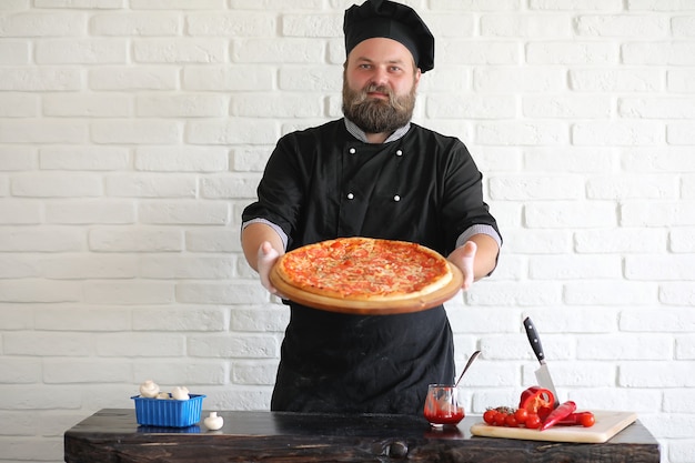 Bearded chef chef prepares meals at the table in the kitchen