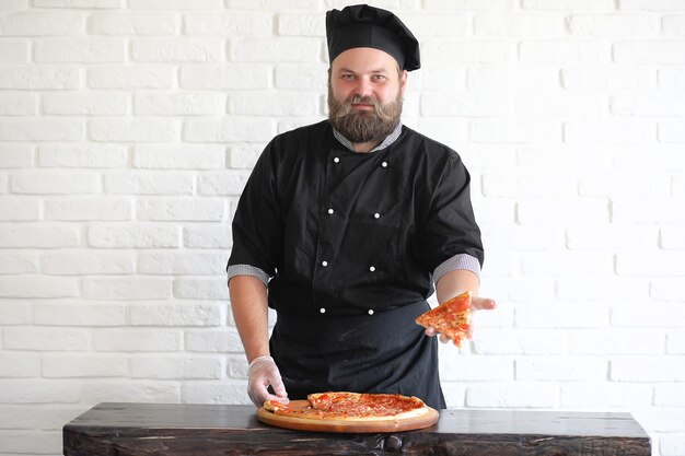 Bearded chef chef prepares meals at the table in the kitchen