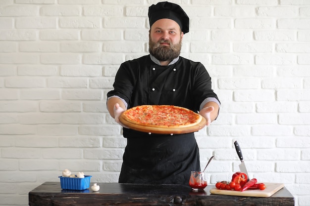 Bearded chef chef prepares meals at the table in the kitchen