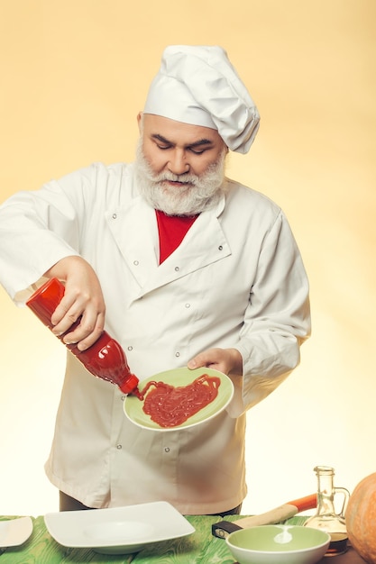 Bearded cook with ketchup bottle