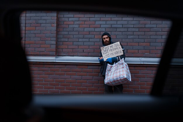 Photo bearded dirty homeless begging on city street.