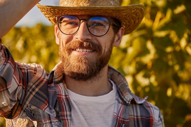 Бородатый фермер на винограднике в сезон сбора урожая