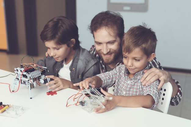 Bearded Father and Sons Constructing Robot at Home