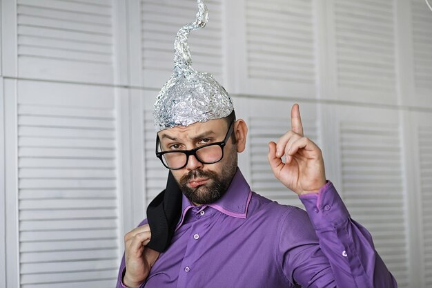 Photo bearded funny man in a cap of aluminum foil concept art phobiasconspiracy theory conspiracy insanity