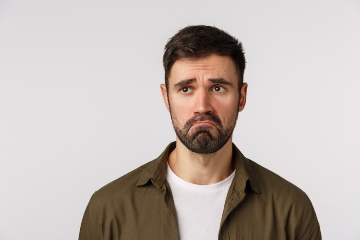 Photo 悲しい顔をした茶色のコートを着たひげを生やした男
