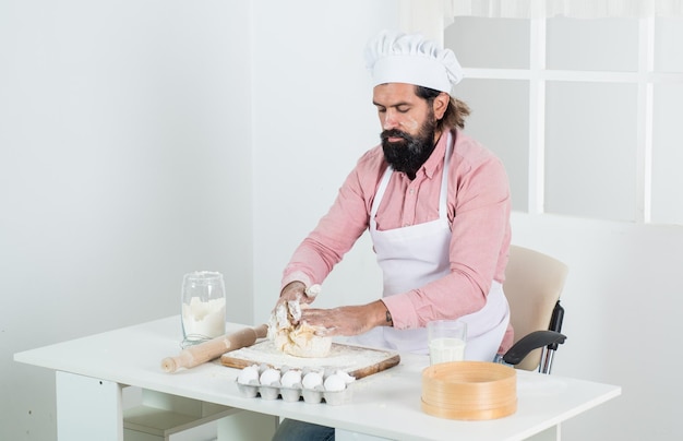 Bearded guy cook preparing food in home kitchen cook