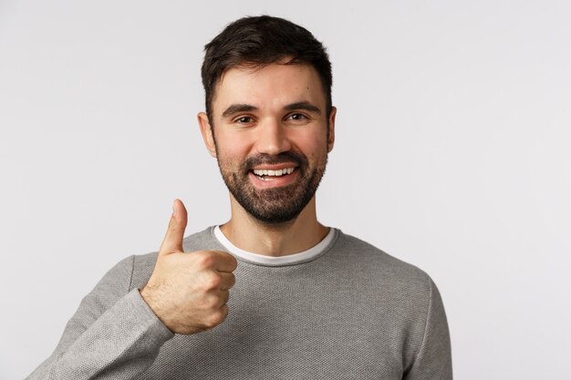 Bearded guy in grey sweater giving thumb up