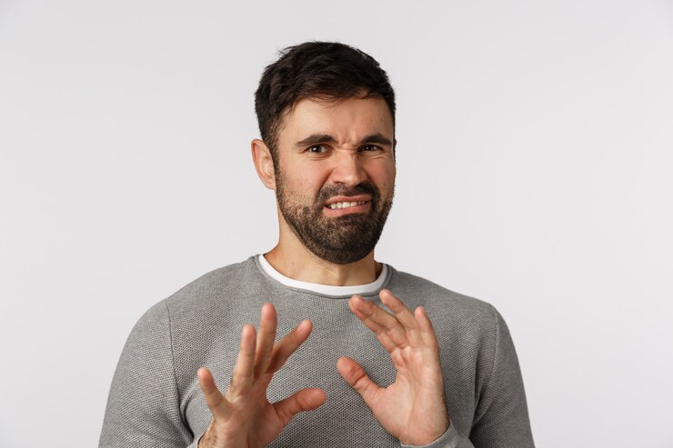 Photo bearded guy in grey sweater grimacing