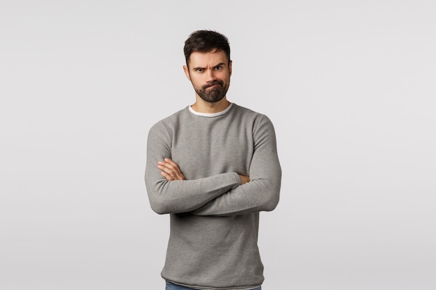 Bearded guy in grey sweater with crossed arms