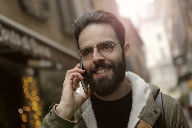 Ragazzo barbuto parlando su uno smartphone