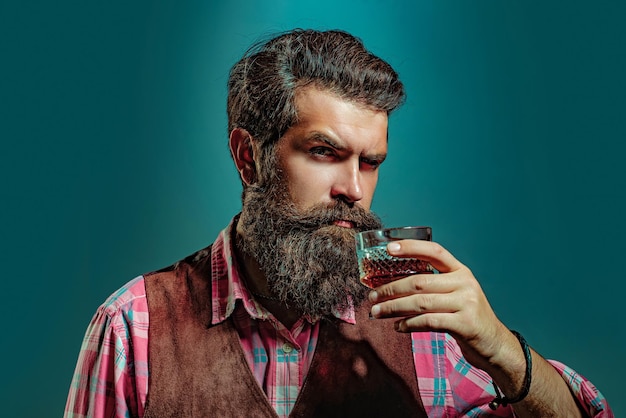 Бородатый красавец, держащий стакан виски, алкогольная концепция, алкогольный напиток, ретро-винтажный мужчина с w