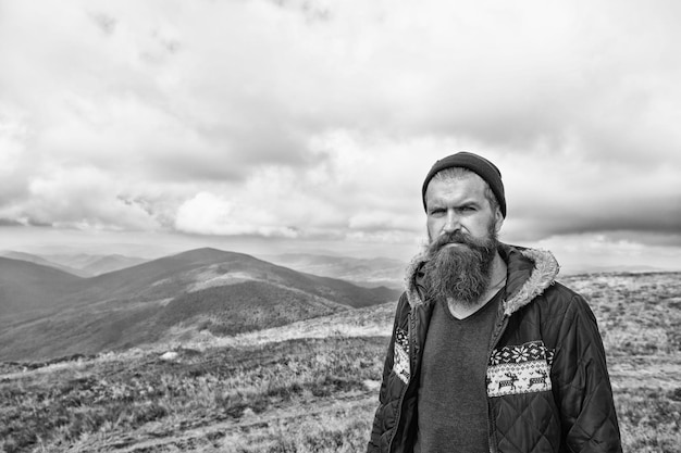 Bearded handsome serious man on mountain top