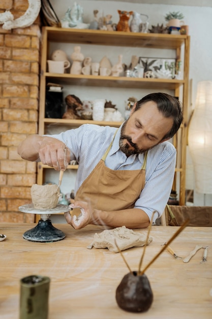 Bearded handyman. Bearded experienced creative handyman working with aroma sticks on the table