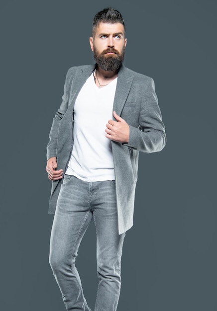 Bearded hipster man wear jacket on grey background