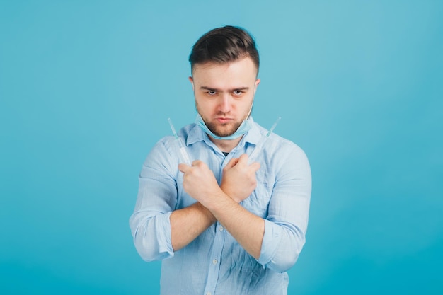 bearded male doctor and holding syringe and shouting on blue background