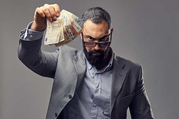 bearded male dressed in a suit catch money banknote in the air.