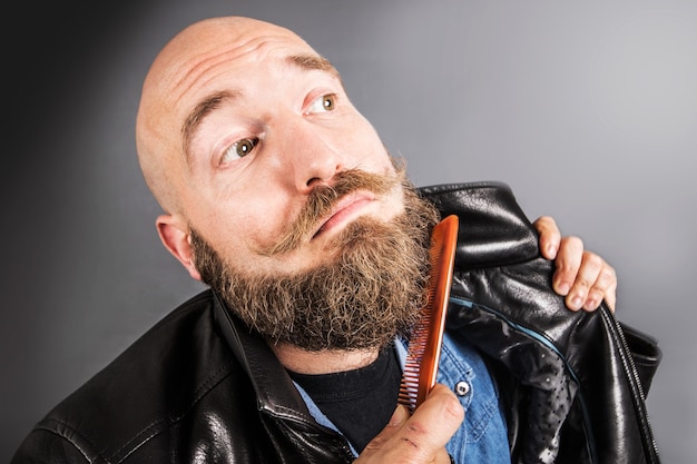 Bearded man arranging his beard with comb