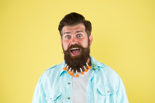 Photo bearded man. bearded man hipster casual style. valentines day. love care my beard hair. laundry. hair drying. barbershop. man clothespin on beard. brutal male put clothespin with hearts on beard.