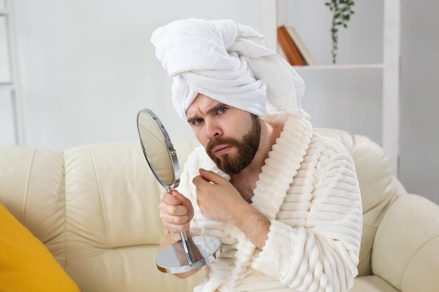 Bearded man checking his skin of face. spa, body and skin care\
for male concept.