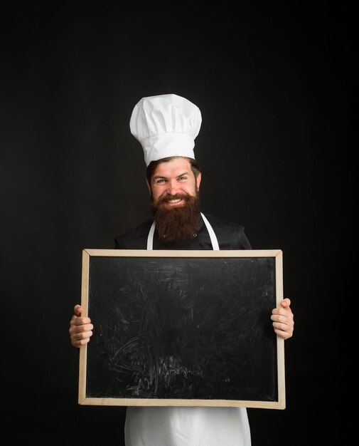 Bearded man cook or chef holds empty board in cooking school master cook giving cooking class chef