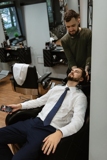 Bearded man cutting his beard in the barbershop