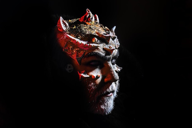 Бородатый мужчина, одетый как хэллоуинский монстр, хэллоуинское искусство, кровавая кожа, портрет лица человека, крупный план, дьявол