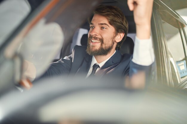 Bearded man driving a car trip luxury lifestyle self\
confidence