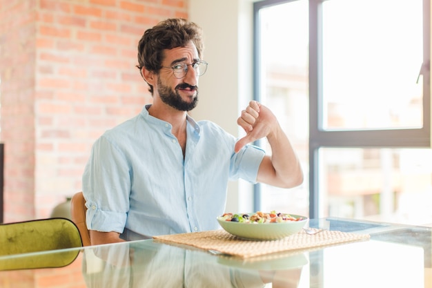 Bearded man feeling cross, angry, annoyed, disappointed or displeased, showing thumbs down with a serious look