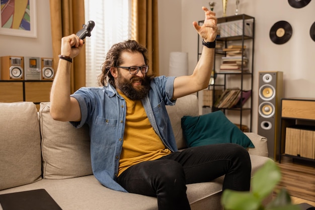 A bearded man full of excitement wins a round of favorite computer game on a console