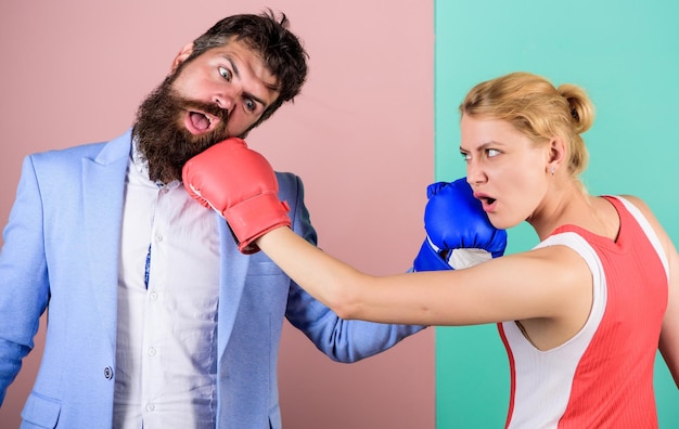 Бородатый мужчина-хипстер борется с женщиной. Сила и мощь, нокаутирующие удары кулаком, кто прав, побеждают в бою, семейная пара, боксерские перчатки, проблемы в отношениях, спорт.