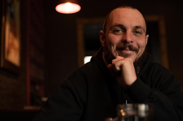 Bearded man holds glass of beer while sitting in pub Beer time Alcohol drinks