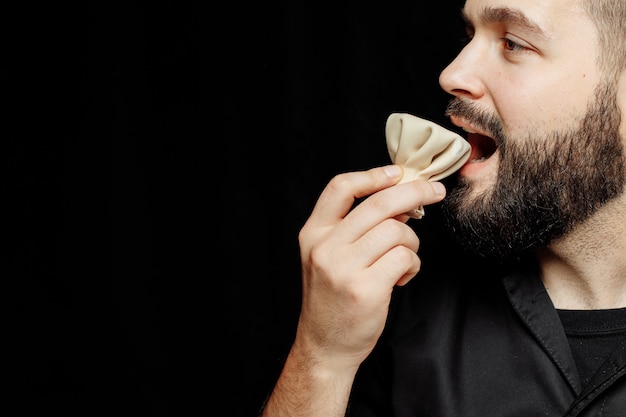 The bearded man is emotionally eating khinkali. The national Georgian dish khinkali.