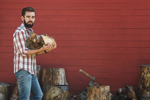 Bearded man is holding firewoods